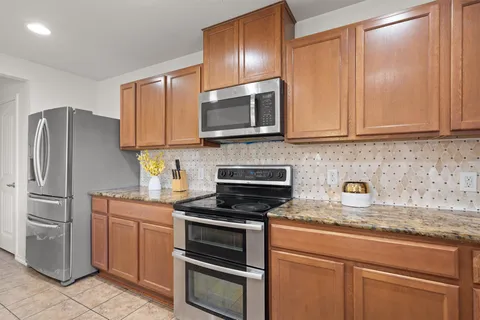 a kitchen with granite countertop cabinets stainless steel appliances and a sink