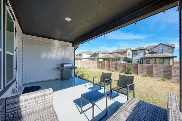 a view of a patio with a table chairs and a grill