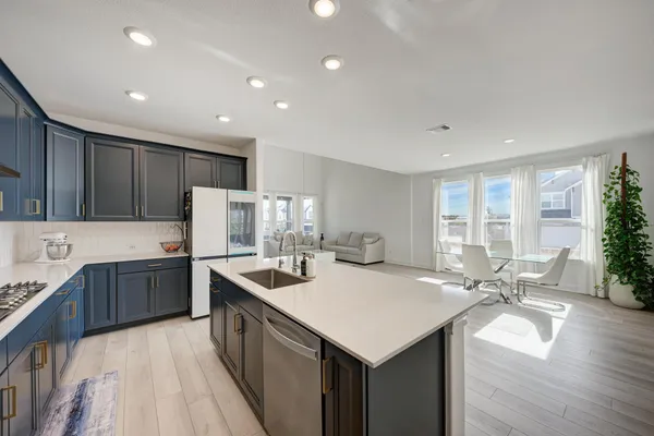 a kitchen with a sink a counter top space stainless steel appliances and cabinets