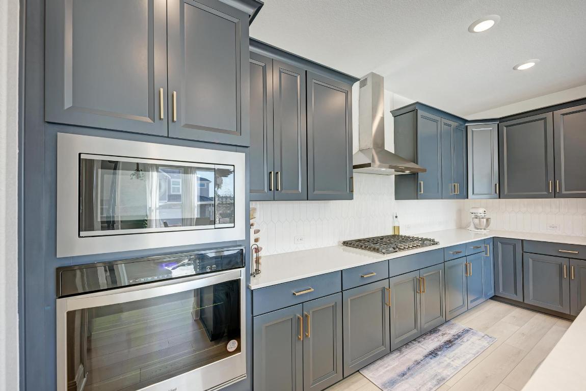 316 Regatta Trail Leander, TX 78641 - Photo 8 of 40 a kitchen with stainless steel appliances granite countertop a sink stove and refrigerator
