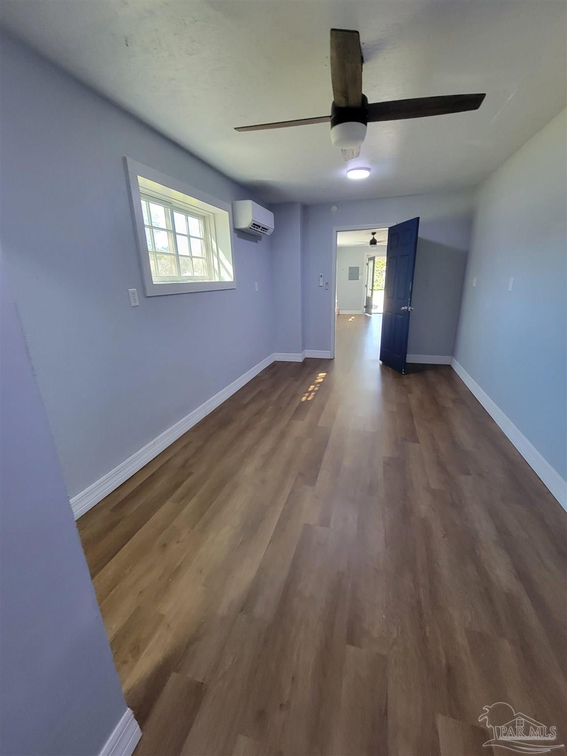 3217 Wallace Lake Road Pace, FL 32571 - Photo 11 of 17 a view of an empty room with a window and wooden floor