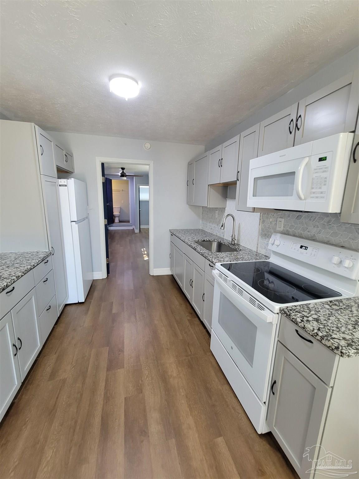 3217 Wallace Lake Road Pace, FL 32571 - Photo 8 of 17 a kitchen with white cabinets and white appliances