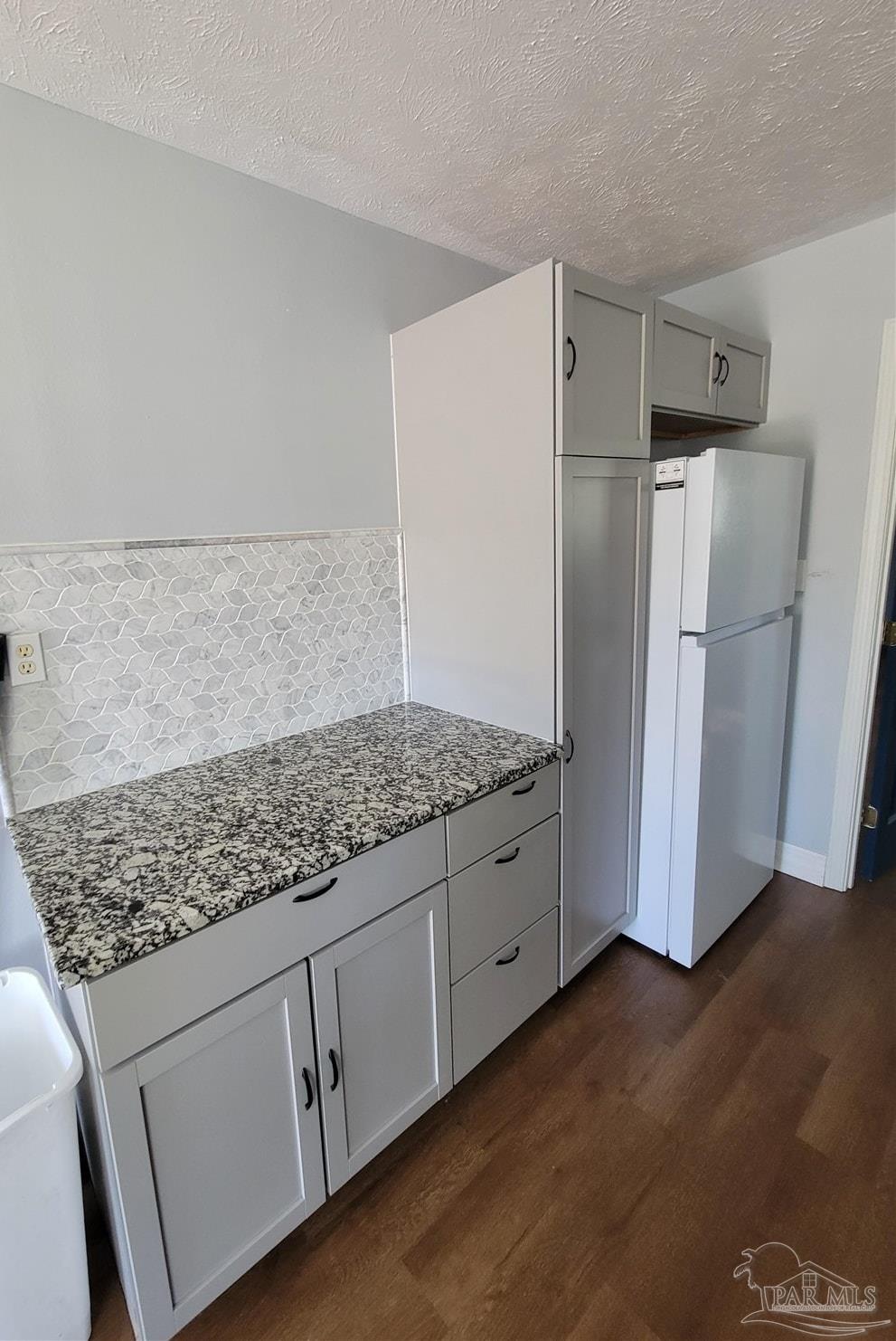 3217 Wallace Lake Road Pace, FL 32571 - Photo 9 of 17 a kitchen with granite countertop white cabinets and refrigerator