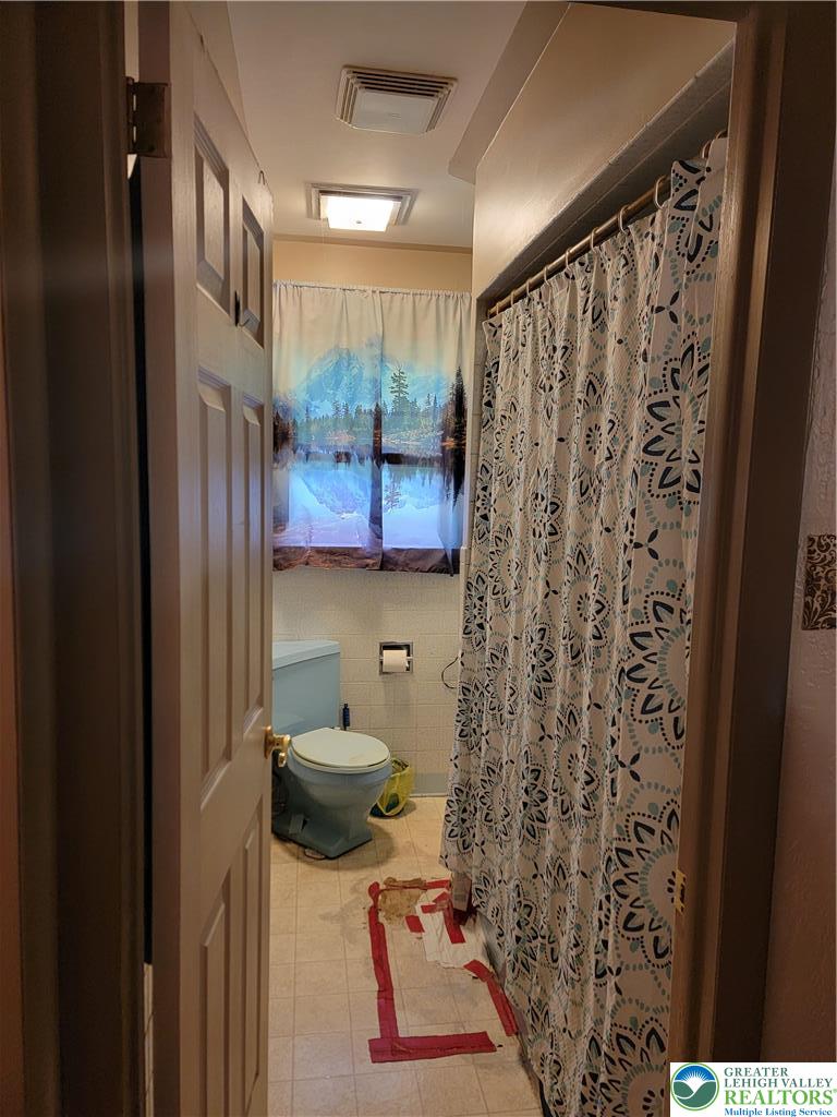 320 Hillside Street Forest City, PA 18421 - Photo 15 of 24 a bathroom with a toilet and a shower curtain