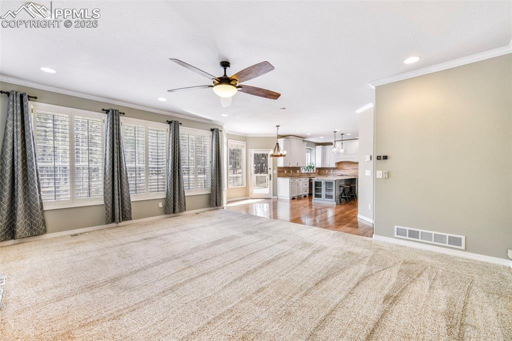 17725 Martingale Road Monument, CO 80132 - Photo 14 of 50 a view of a kitchen with kitchen island wooden floor and a ceiling fan