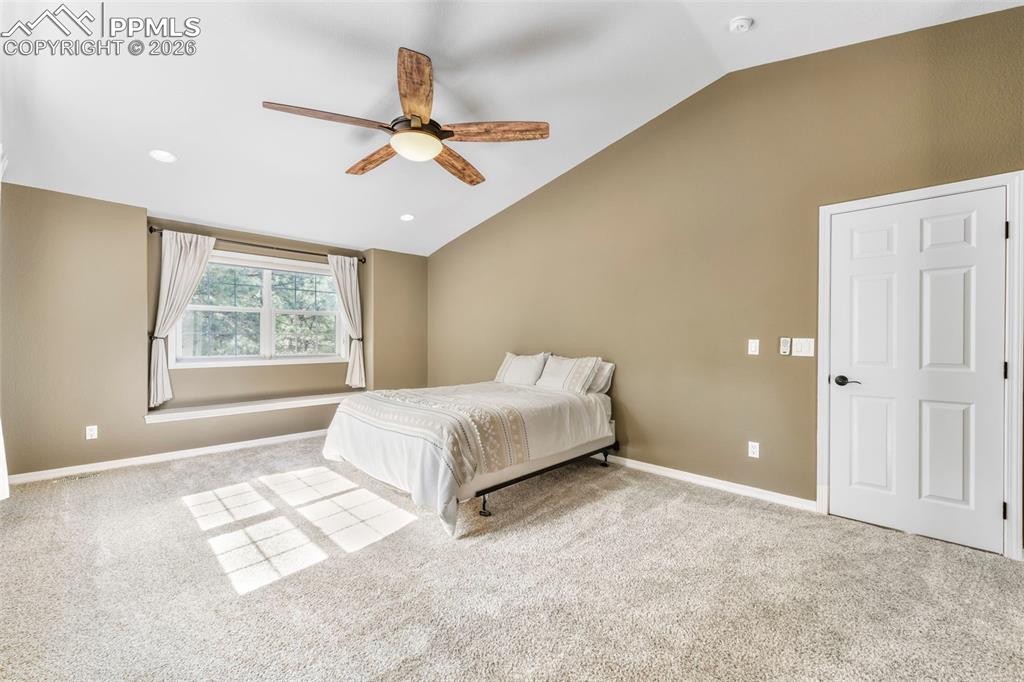 17725 Martingale Road Monument, CO 80132 - Photo 16 of 50 a spacious bedroom with a large bed and a window