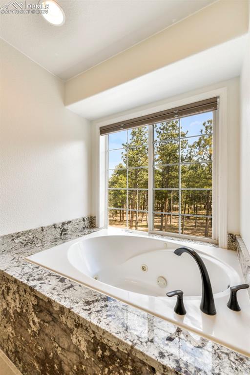 17725 Martingale Road Monument, CO 80132 - Photo 20 of 50 a bath tub sitting in a bathroom next to a window