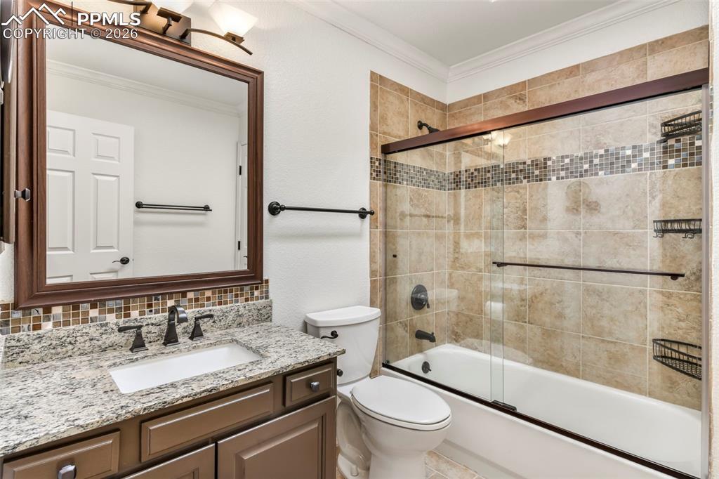 17725 Martingale Road Monument, CO 80132 - Photo 23 of 50 a bathroom with a granite countertop sink toilet and shower