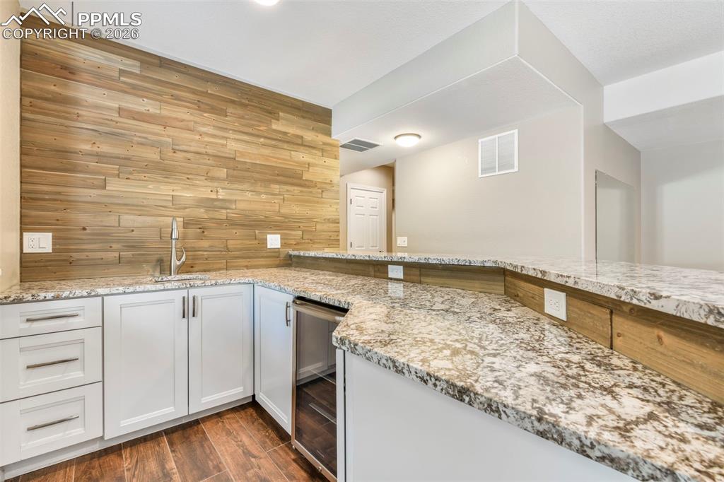 17725 Martingale Road Monument, CO 80132 - Photo 34 of 50 a view of a kitchen with kitchen island a sink stainless steel appliances wooden floor and a window