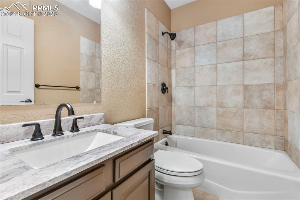 17725 Martingale Road Monument, CO 80132 - Photo 35 of 50 a bathroom with a granite countertop sink a toilet and bathtub