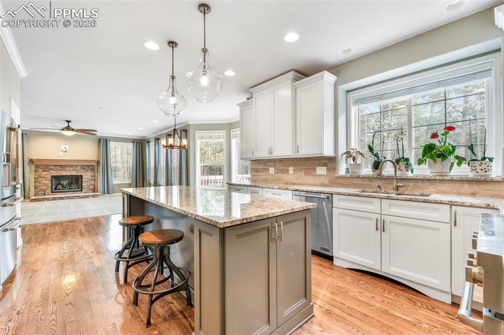 17725 Martingale Road Monument, CO 80132 - Photo 9 of 50 a large kitchen with kitchen island granite countertop a large center island and a wooden floors
