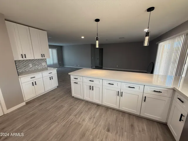 a kitchen with granite countertop white cabinets and white appliances