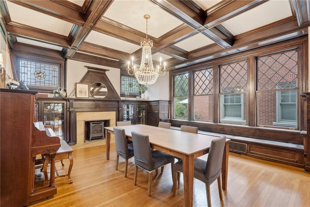 4749 Wallingford Street Pittsburgh, PA 15213 - Photo 7 of 49 a dining room with furniture a fireplace and a chandelier