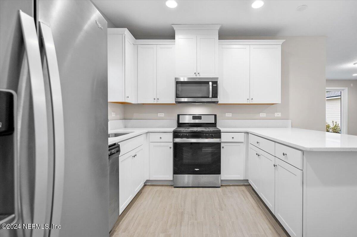70 Stargaze Lane St. Augustine, FL 32095 - Photo 6 of 41 a kitchen with white cabinets and stainless steel appliances