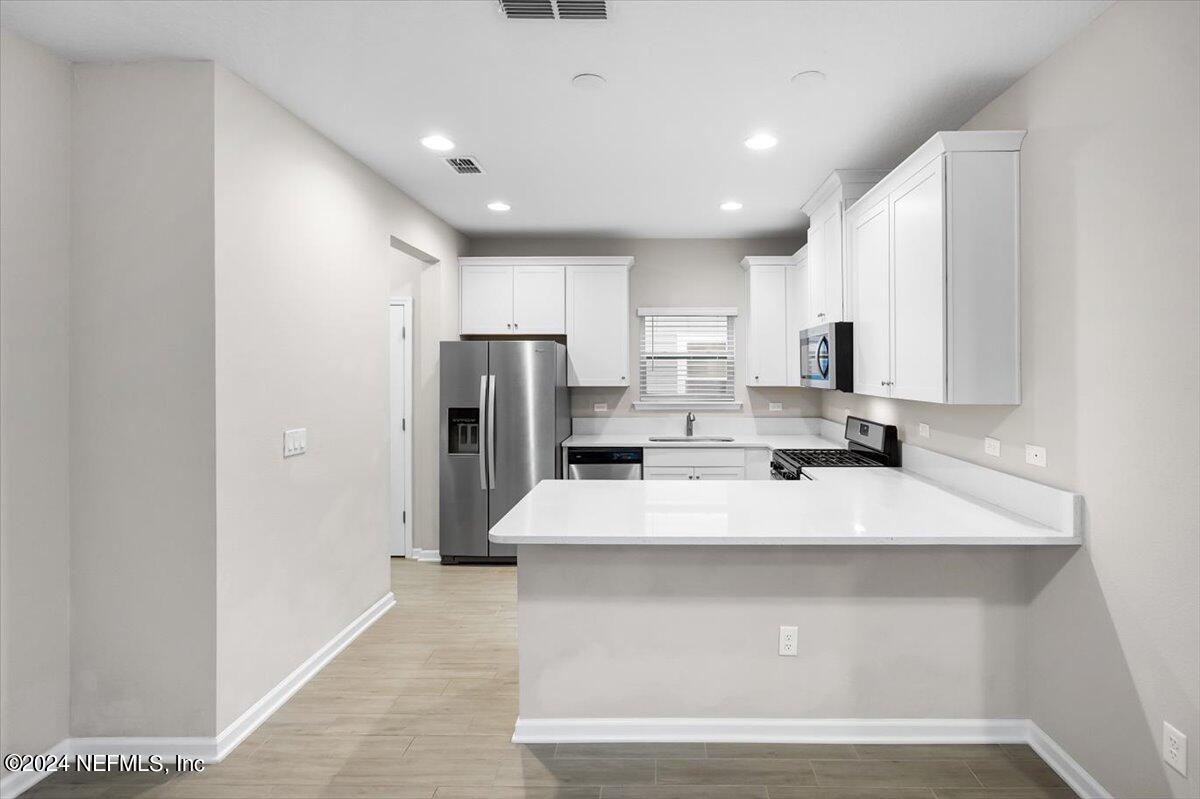 70 Stargaze Lane St. Augustine, FL 32095 - Photo 7 of 41 a large white kitchen with kitchen island a sink stainless steel appliances and cabinets