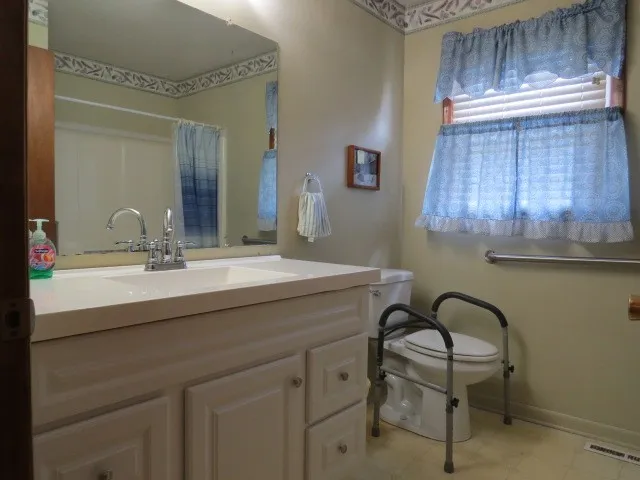 a bathroom with a sink a light fixture and a mirror