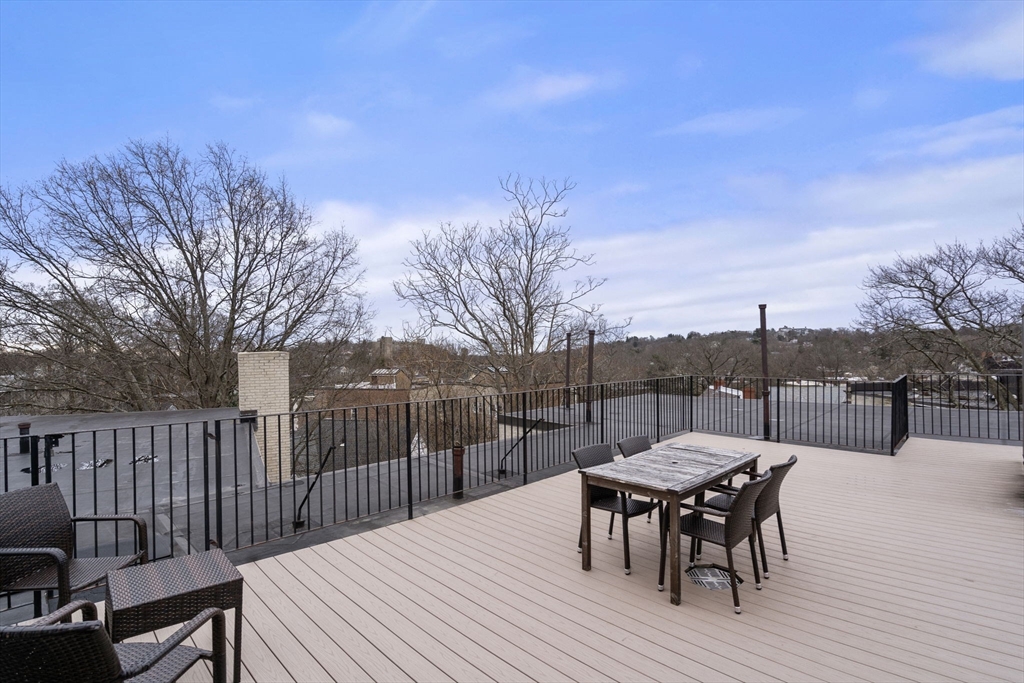 90 Kilsyth Road, Unit 2 Boston, MA 02135 - Photo 16 of 18 a view of a roof deck with table and chairs and wooden floor