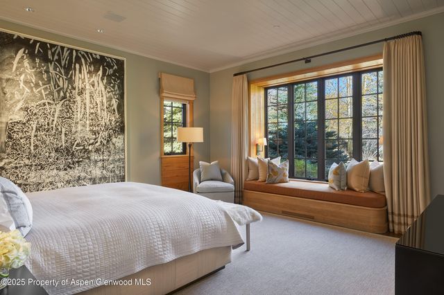 a bedroom with a bed and a couch next to a window