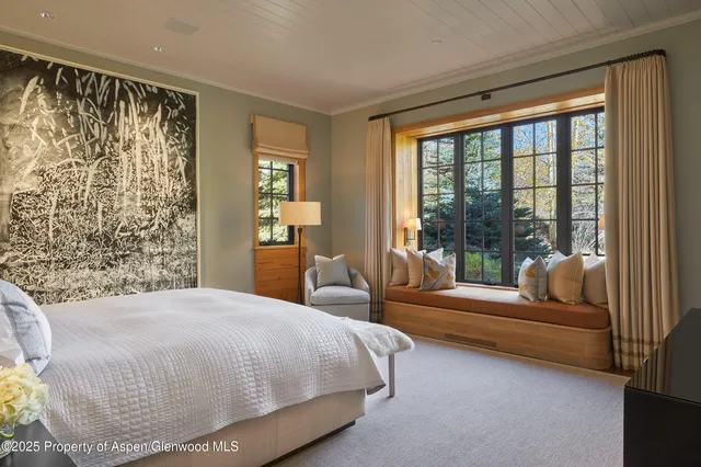 a bedroom with a bed and a couch next to a window