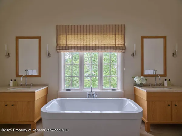a bathroom with a tub a sink and a window