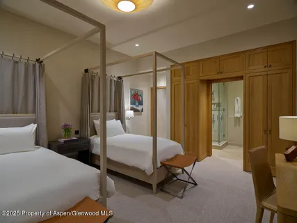 a bedroom with a bed a table and a mirror