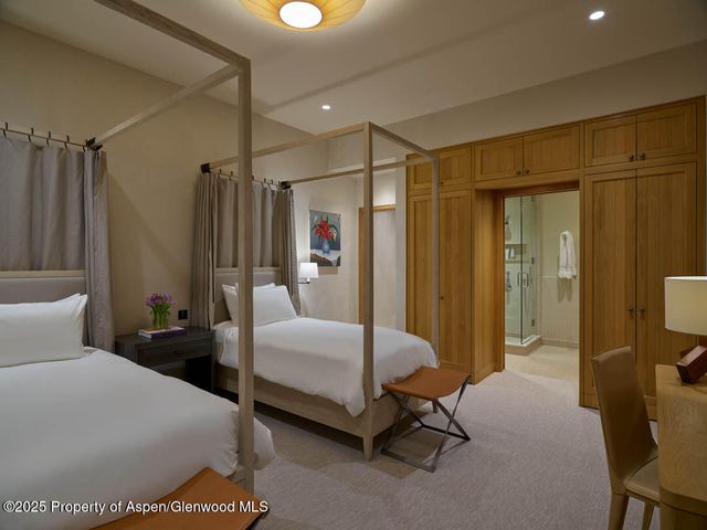 a bedroom with a bed a table and a mirror