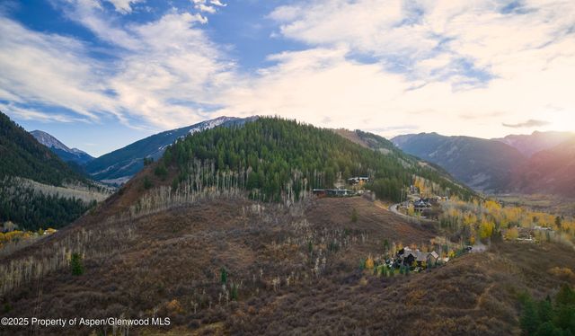 a view of a dry yard with mountains in the background