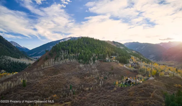 a view of a dry yard with mountains in the background
