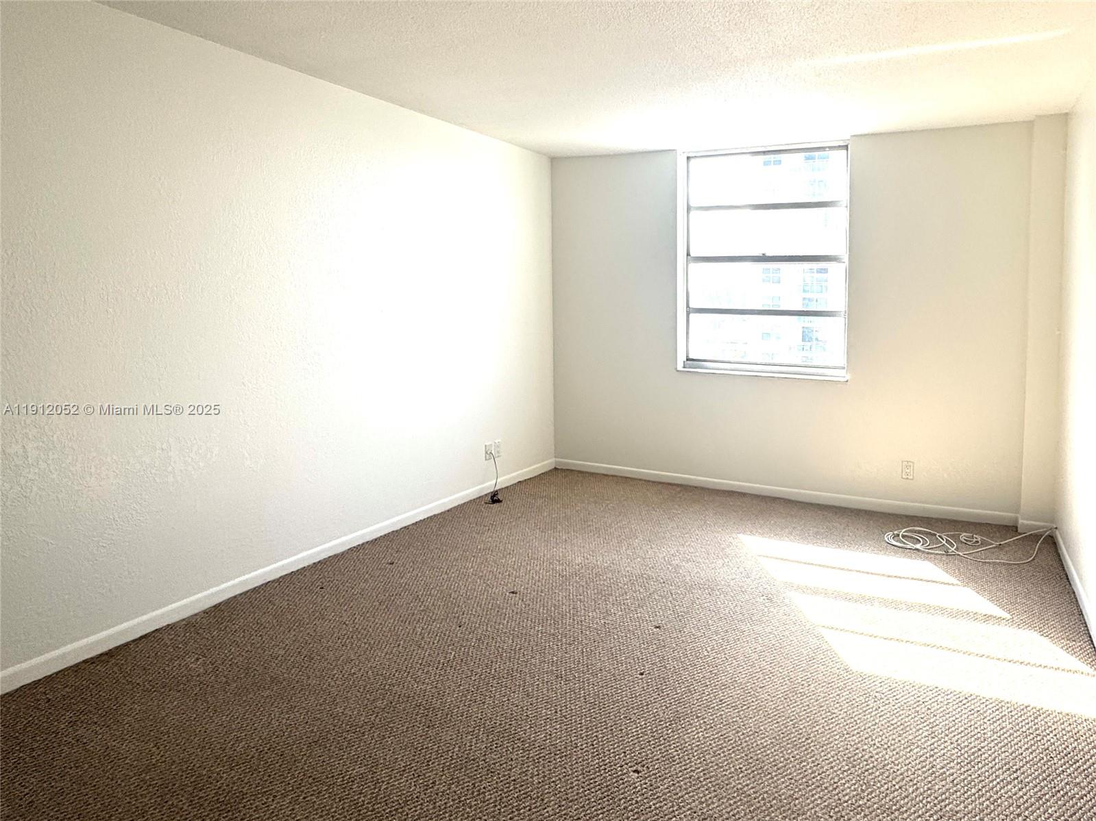 430 Golden Isles Drive, Unit 701 Hallandale Beach, FL 33009 - Photo 5 of 11 an empty room with windows