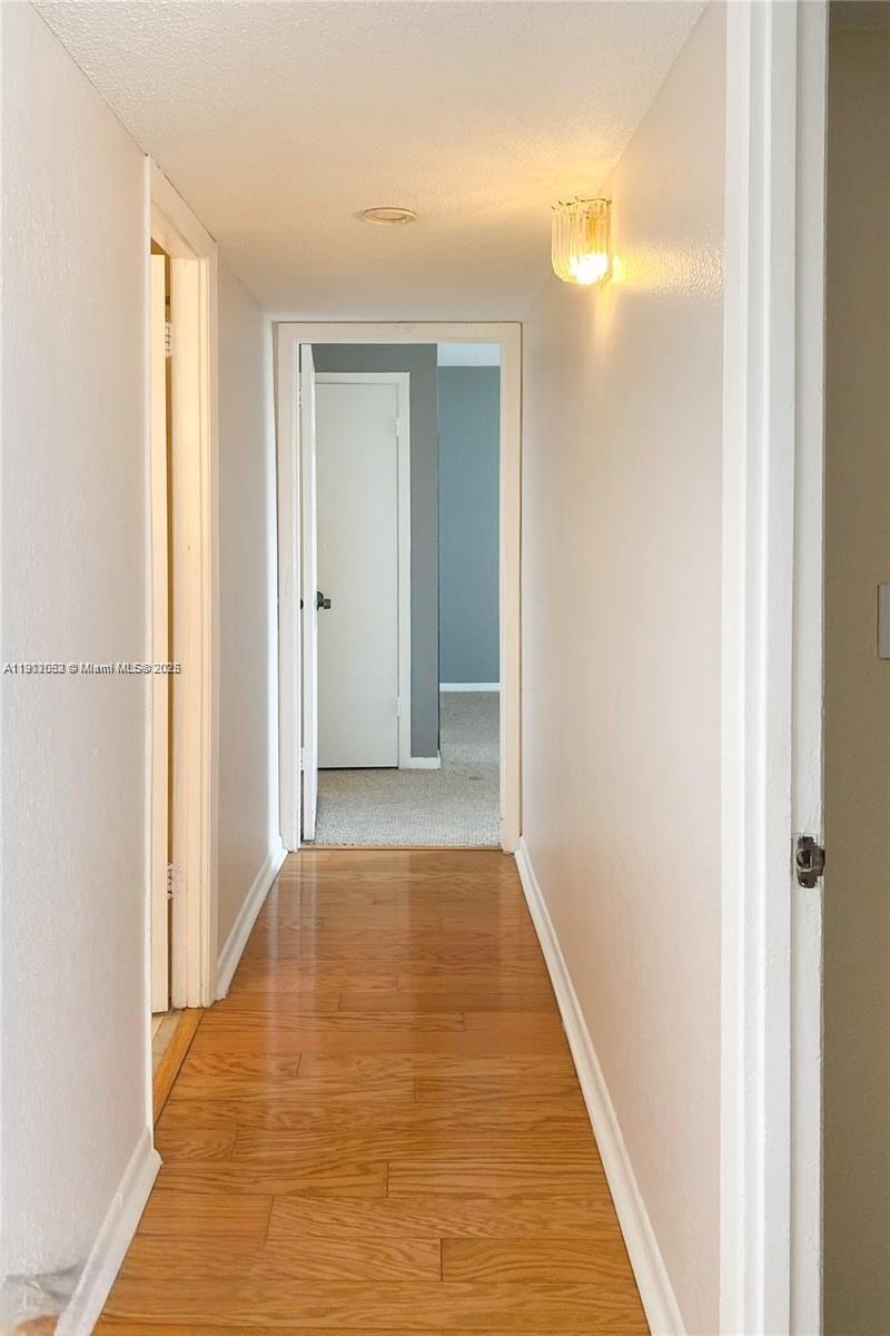 430 Golden Isles Drive, Unit 701 Hallandale Beach, FL 33009 - Photo 8 of 11 a view of a hallway with wooden floor