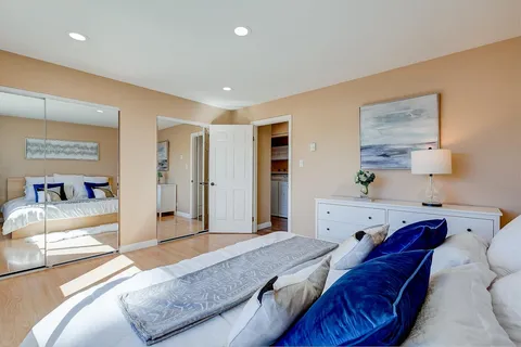 a spacious bedroom with a bed and wooden floor