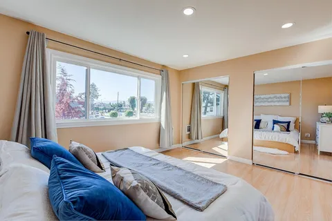 a bedroom with a large bed and a painting on the wall