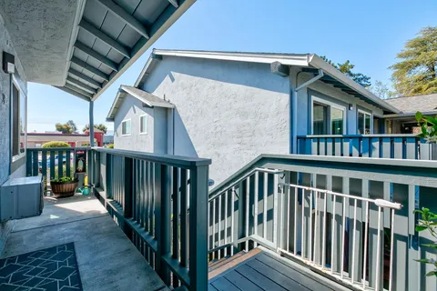 a view of a house with wooden deck and furniture