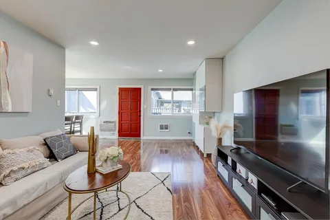 a living room with furniture and a wooden floor