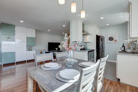 a kitchen with stainless steel appliances kitchen island granite countertop a dining table and chairs