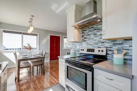 a kitchen with a stove a sink a dining table and chairs
