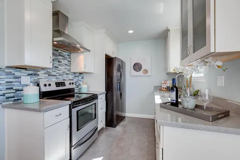 a kitchen with stainless steel appliances granite countertop a sink stove and refrigerator