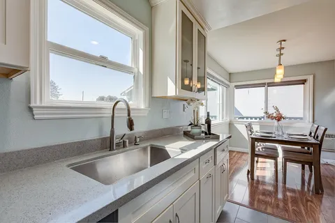 a kitchen with a sink a counter top space and cabinets