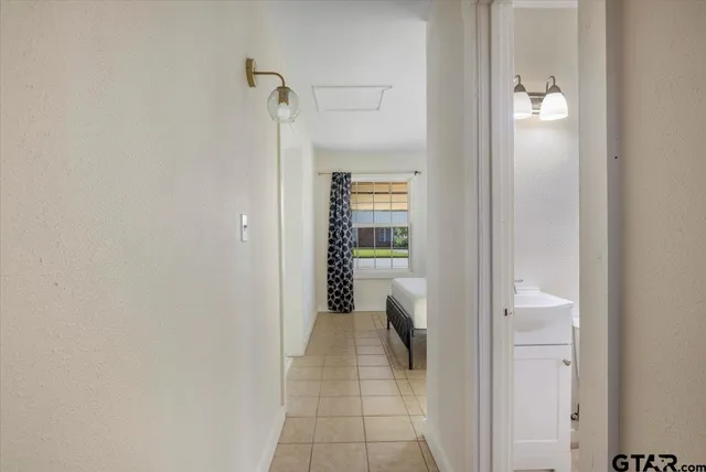 a view of a hallway with closet and a fireplace