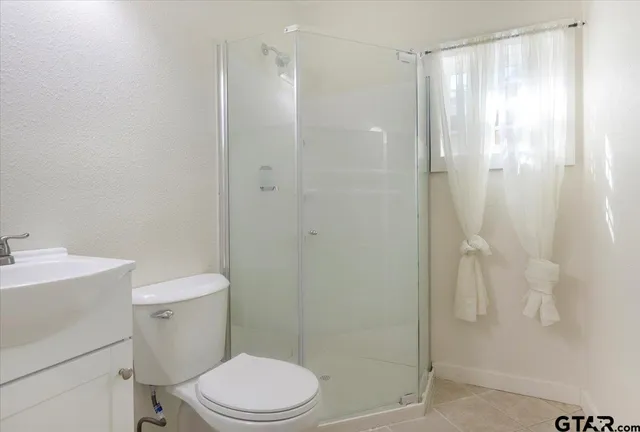a bathroom with a shower a toilet and sink