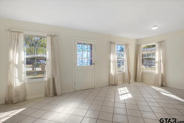 a view of an empty room with window and cabinet area