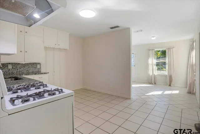 a kitchen with a stove a refrigerator and cabinets