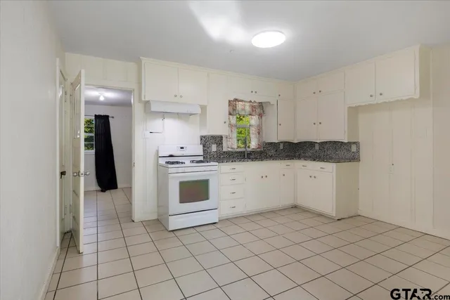 a kitchen with a stove sink and cabinets