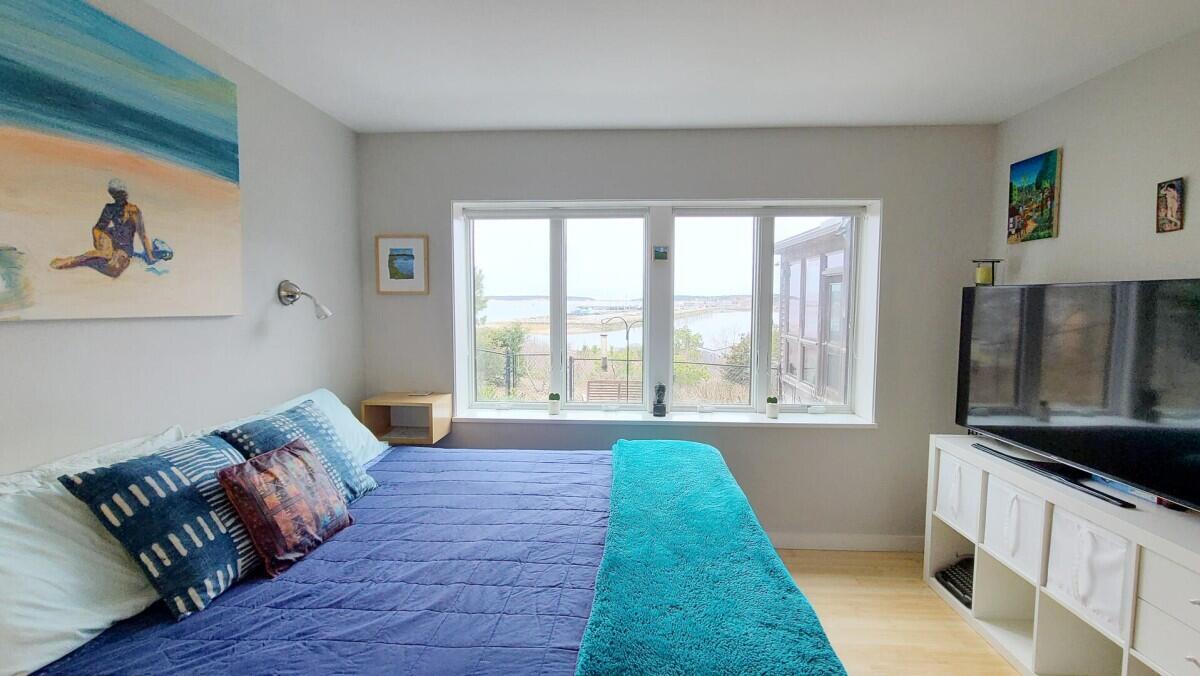 75 Richman Lane Wellfleet, MA 02667 - Photo 19 of 72 a spacious bedroom with a bed and a large window