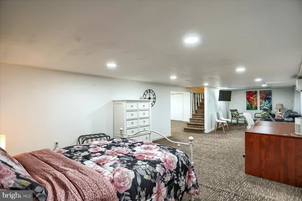 a bedroom with a bed a couch and large dresser