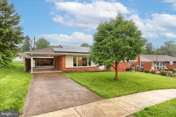 a front view of a house with a garden and trees