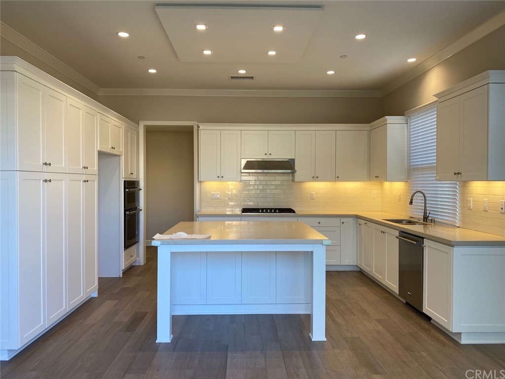63 Singer Irvine, CA 92620 - Photo 10 of 33 a kitchen with kitchen island granite countertop wooden floors and stainless steel appliances