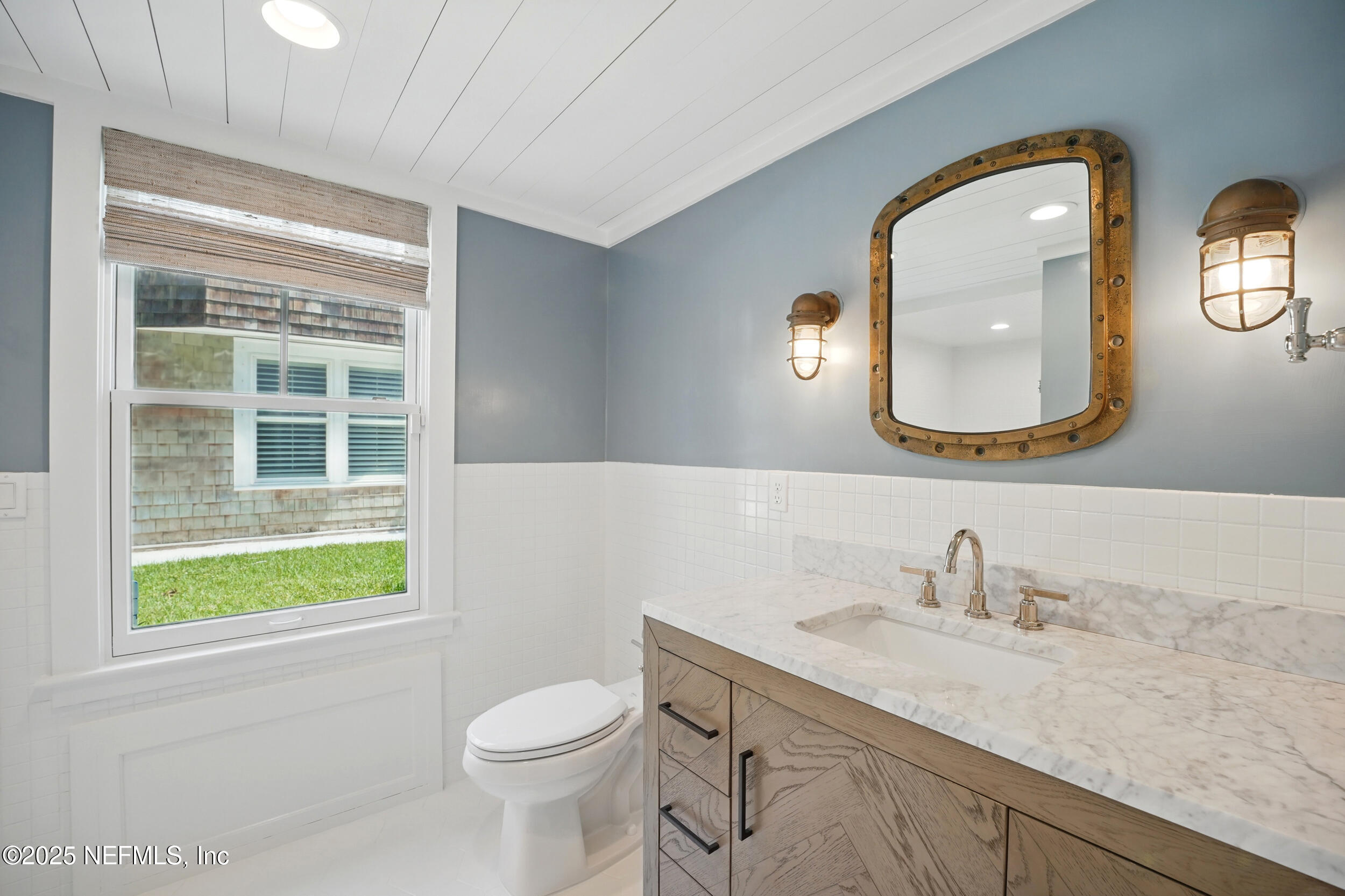 816 Ocean Front Neptune Beach, FL 32266 - Photo 36 of 65 a bathroom with a granite countertop toilet a sink and a mirror