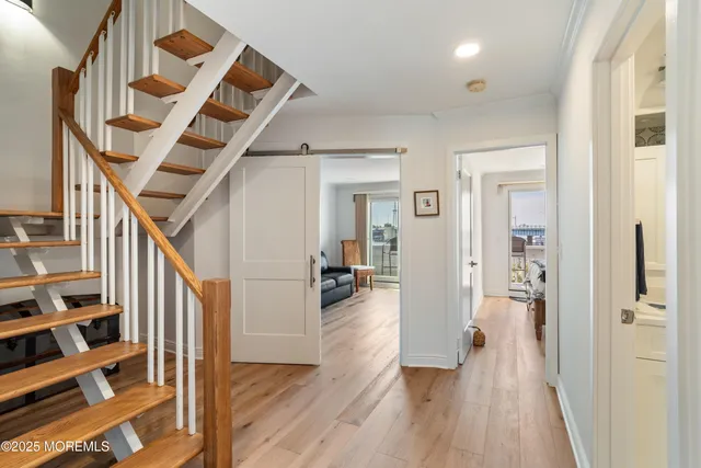 a view of hallway with wooden floor and stairs