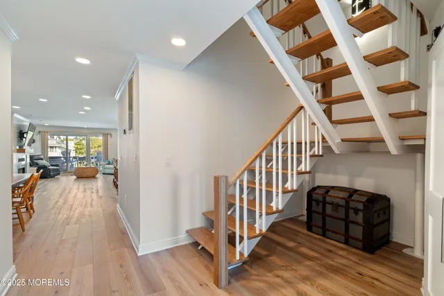 a view of a hallway with wooden floor and staircase